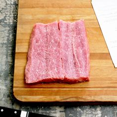 raw meat sitting on top of a wooden cutting board