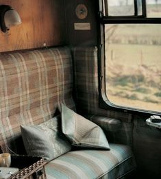 the inside of a train car with pillows and blankets on it's seat area