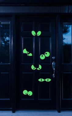 the door is decorated with green alien heads and eyes, as well as two black doors