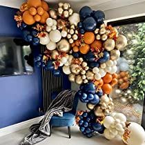 balloons are hanging from the ceiling in front of a window with an orange, white and blue theme