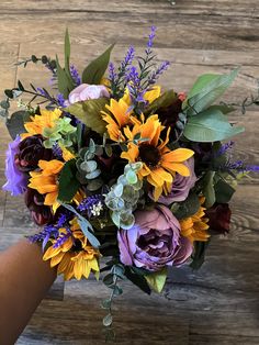 a bouquet of sunflowers, roses and greenery