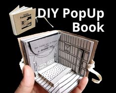 a hand holding an open book with the title diy pop up book