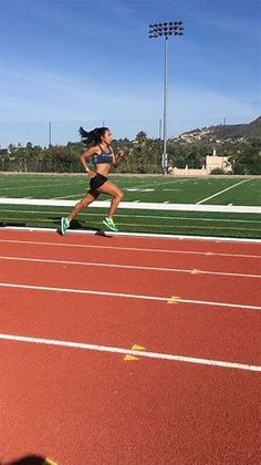 a woman running on a track in a stadium