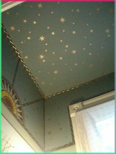 the ceiling has stars painted on it and is blue with gold trimmings, along with a window