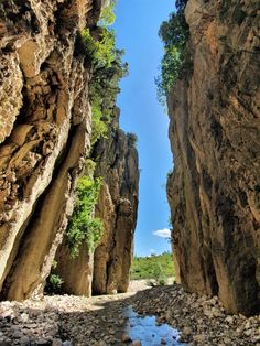 a narrow canyon with rocks and water on both sides