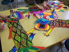 children are making colorful paper puppets on the table