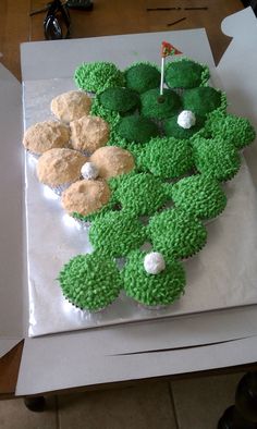 a cake made to look like a golf course with cupcakes on the top