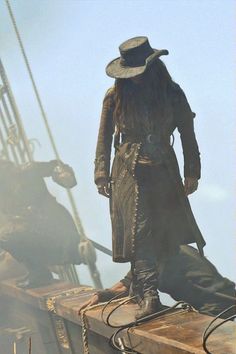 a pirate standing on top of a wooden boat