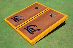 two cornhole game boards sitting on top of a green grass covered field next to each other