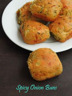 some food is on a white plate and sits on a table with the words spicy onion buns