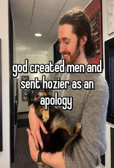 a man holding a small dog in his arms with the caption god created men and sent hozier as an apoloy