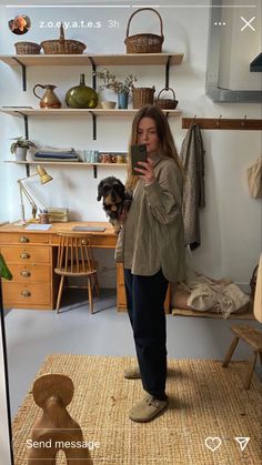 a woman taking a selfie with her dog in front of a room full of shelves