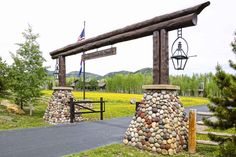 an entrance to a park with rocks on it and a flag flying in the background