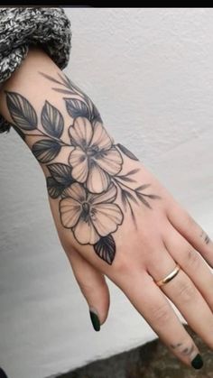 a woman's hand with black and white flowers on it