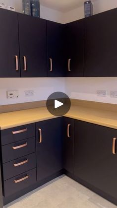 an empty kitchen with black cabinets and gold pulls on the cupboards is shown in this video