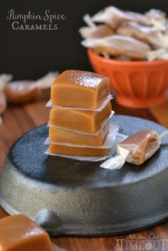 several pieces of caramel sitting on top of a cake pan next to a bowl of marshmallows