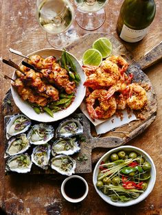 a wooden table topped with plates of food and wine