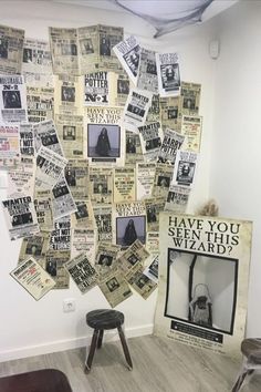 a wall covered in newspapers and pictures next to a stool with a poster on it