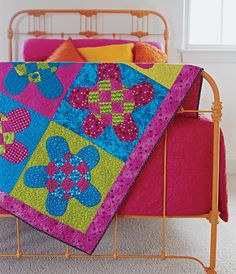 a bed with a quilt on top of it and a metal frame in the foreground