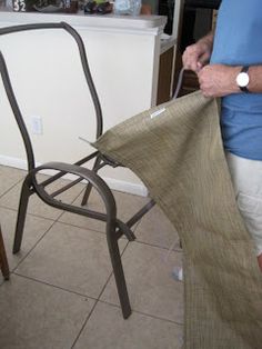 a man is standing next to a chair with a bag on it's back