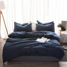 a bed with blue comforter and pillows on it