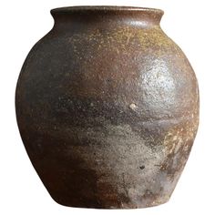 a large brown vase is shown on a white background and has rusted paint all over it