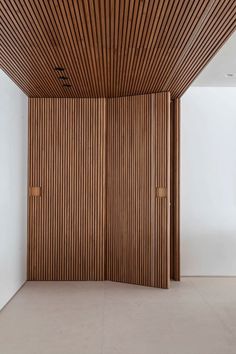 an empty room with wooden slats on the walls