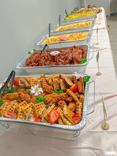 several trays of food are lined up on a table