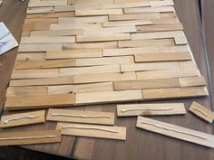 wood planks laid out on a table to make a woven wall hanging or floor mat