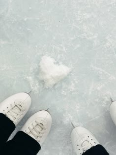 two people standing in the snow with their feet up on an ice floet