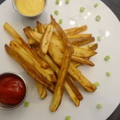 french fries with ketchup and mustard on a white plate