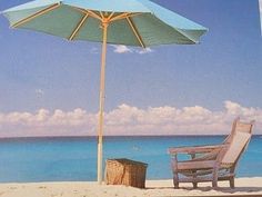 an umbrella and chair on the beach with blue water in the backgroung