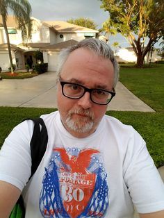 an older man with glasses and a white beard wearing a t - shirt that has the number 80 on it