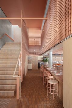 the interior of a restaurant with wooden stairs and tiled flooring, along with tables and chairs