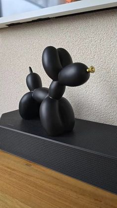 a black sculpture sitting on top of a wooden table