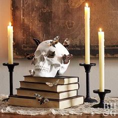 a skull sitting on top of books next to candles