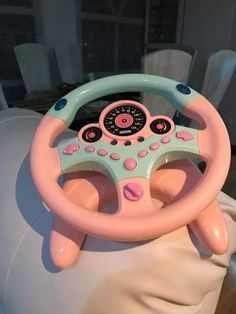 a toy steering wheel sitting on top of a white chair