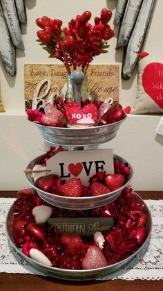 three tiered trays filled with red and white ornaments on top of a table