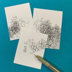 three pieces of paper with black and white drawings on them next to a fountain pen