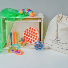 an assortment of toys sitting on top of a table next to a bag and some scissors