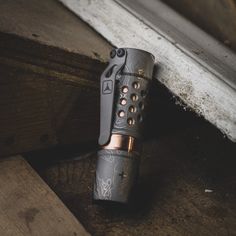 a lighter is sitting on the ground next to some wood planks and a window