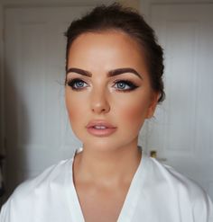 a woman with blue eyes wearing a white shirt