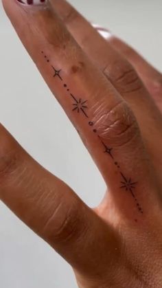 a person's hand with a small star tattoo on it