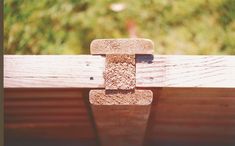 the corner of a wooden bench with a piece of wood sticking out of it