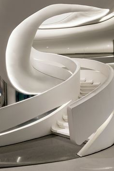 the interior of a modern building with curved white walls