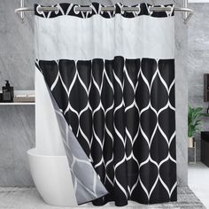 a black and white shower curtain with an abstract design on it in a modern bathroom