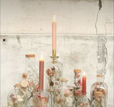 several glass jars filled with flowers and candles