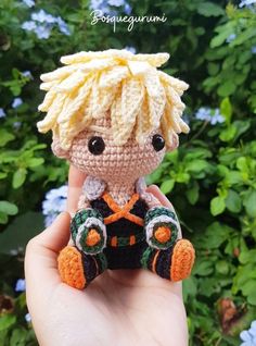 a hand holding a tiny crocheted doll with blonde hair