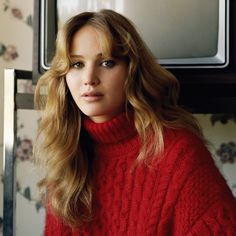 a woman wearing a red sweater in front of a microwave