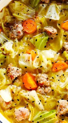 a white bowl filled with meat and cabbage soup on top of a wooden cutting board